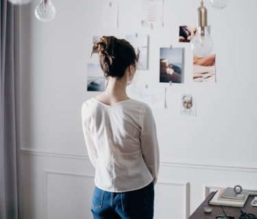 woman standing looking at photos on wall
